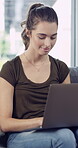 University, typing and woman in house with laptop, research or online assignment in student portal. Reading, college or female person on sofa with tech, virtual course or digital report in e learning