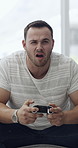 Angry, man and gamer with loss for failure, bad challenge or frustration on sofa in home. Frustrated, man or playing game with controller, fight or stress on console for mistake or difficult match