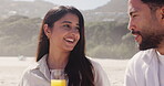 Date, orange juice and talking with couple on beach together for bonding, love or romance. Drink, smile and weekend with happy people outdoor on coast for holiday, travel or vacation in summer