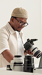Black man, laptop and camera in workshop for photography, project management or review at media company. Person, photographer and smile with computer, editing or production process at creative agency