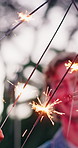 Hands, smile and sparklers with friends for celebration, outdoor and fireworks for new years eve. People, group and together for reunion on vacation, holiday or summer break at sunset for community