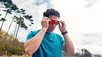 Mountain, breathe and man with sunglasses for running, exercise and workout for wellness. Sports, fitness and person with eyewear ready for challenge, active hobby and training for health outdoor