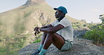 Break, breathing and hiking with black man in nature for adventure, fitness or sports hobby. Relax, scenery and view with African hiker person on rock in mountains for exercise, peace or thinking