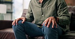 Anxiety, hands and man on sofa with stress, overthinking or mistake with wrong decision in lounge. Home, coping mechanism and nervous person with worry, trauma or stimming for mental health crisis