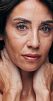 Face, skincare and serious woman with natural beauty, aesthetic and healthy skin in studio. Portrait, dermatology and mature person with cosmetics for anti aging, confident and touch for self care