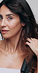 Brush, styling and face of woman in studio with grooming, shine or texture with hair care. Health, beauty and portrait of mature female person with comb for long hairstyle by white background.