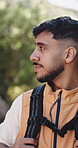 Smile, hiking and man with travel in nature, sightseeing and backpacking adventure for eco tourism. Bokeh, outdoor exploration and person with trekking journey in forest, happy and holiday activity