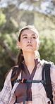 Woman, hiking and adventure in forest with sightseeing, backpack and vacation activity for wellness. Bokeh, person trekking or journey outdoor with bag for nature exploration, travel or tourist trip.