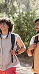 Friends, hiking and backpack in forest with wellness, adventure and discussion for bonding together. Bokeh, people and trekking outdoor on trail with bag, nature exploration and travel conversation.