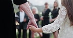 Person, holding hands and child at graveyard for funeral ceremony, burial service and mourning loss. Casket, family and kid bereavement, emotional ritual and tribute gathering at farewell memorial 