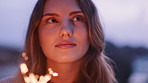 Outdoor, thinking or woman with sparklers for vacation, new year celebration or goal setting on travel trip. Firework, sunset or person with reflection for holiday, nature or remember happy memory