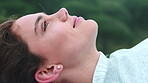 Woman, laying and relax with smile at park for thinking, reflection and break in nature with memory. Girl, rest and happy with breathing, perspective and lying with profile on ground for daydream