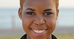 Laughing, face and black woman with smile by beach, funny memory and travel destination for weekend trip. Portrait, spring break or happy student with vacation adventure by boardwalk, outdoor or joke