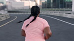 Back, ponytail and running with woman on bridge in city for cardio training or workout routine. Exercise, health and wellness with runner outdoor in urban town for challenge, fitness or pace