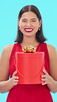 Face, smile and woman in studio, gift for celebration and excited on blue background. Happiness, birthday party and person with present for surprise, wow and winner with giveaway, prize and package