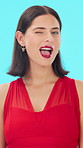 Face, smile or woman with wink in studio for love, romantic gesture or flirting expression for valentines day. Laughing, confident or person with affection reaction for date, emoji or blue background