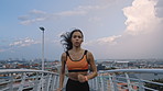Fitness, sprinting or woman on bridge with earphones, cardio playlist or stamina exercise in speed activity. Fast, tech or athlete with intense run, sports podcast or endurance workout in city.