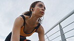 Woman, mark and start running in city with earphones, intense exercise or endurance training outdoor. Low angle, person or runner breathing on bridge with audio tech, begin sprint and cardio workout.