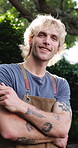 Happy, face and man with apron for bbq, host and getting ready for outdoor event or culinary skills. Backyard, portrait and person with arms crossed on holiday, home and smile with grilling equipment