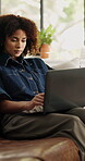 Business, woman and typing on laptop on sofa for news article, editing submission and remote work. Freelance journalist, african person and tech in home for blog post, online research and publication