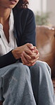 Hands, woman and nervous in counseling on sofa for emotional tension, share trauma and recovery. Mental health, stress and patient with consultation for healing, reflection and overwhelmed by memory
