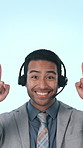 Call center, pointing and face of man in studio for announcement, info and mockup space. Corporate, portrait and person with headset for customer service, contact us or advertising on blue background