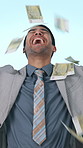 Money, rain and business man in studio with success for investment, stock market and trading. Corporate, excited and person celebrate with cash for profit, bonus or finance growth on blue background