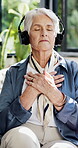 Headphones, meditation and breathing with old woman on sofa in home for peace, relax and sound. Zen music, spiritual connection and holistic subscription with senior person in house for yoga audio