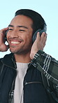 Happy, dance and man in studio with headphones for streaming, stress relief and relax with audio. Excited, travel and person with subscription for music, radio and playlist on blue background