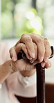 Walking stick, hands or old person in house with rehabilitation, parkinson or medical care in retirement. Cane, bokeh or elderly woman with disability, mobility aid or arthritis in nursing home.