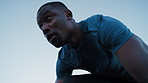 Black man, runner and outdoor for start with sprint for form, coordination and launch in wind for fitness. African person, low angle and training for speed, cardio exercise and workout with blue sky