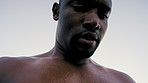 Man, runner and strap for heart rate in city with sweat, monitor and low angle on break for fitness. African person, wearable tech and rest with cardio, thinking or breathing for exercise in summer