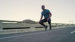 Man, jump and jog on spot in city with fitness, warm up and muscle wellness on urban bridge. African person, runner and ready for cardio exercise, circulation and flexibility with summer in town