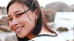 Wellness, face or Asian woman at beach with wind, positive attitude or chill on weekend break. Peaceful, portrait or female person at ocean with fresh air, good mood or outdoor getaway in New Zealand