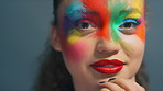 Woman, face paint and skin art in studio with beauty, color and cosmetics with smile on background. Girl, happy and makeup for mask, confident or portrait with splash for aesthetic in Costa Rica