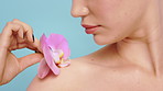 Beauty, hand and plant with woman on studio background for cosmetics or dermatology. Organic, soft or vegan skincare and shoulder of model with orchid flower for satisfaction or sustainability