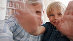 Face, grandfather and child on video call, waving or excited kid with peace sign in lounge. Portrait, boy and grandparent with online chat, hand gesture or hello for greeting with POV in family home