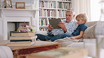 Grandpa, boy and relax with tablet on sofa with discussion, games or click for contest in living room. Grandfather, child and tech with virtual puzzle, explain or guide on application at family house