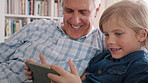 Grandfather, boy and play in home with tablet, online game and happy for bonding together on weekend. Senior man, grandchild and conversation in living room with tech, smile and kids app for gaming.