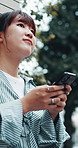 Travel, girl and typing with phone in city for direction search, online location and holiday abroad. Bokeh, asian tourist and smartphone in urban town for internet guide, web navigation and low angle