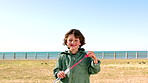 Outdoor, bubbles and face of boy with smile, beach park and summer travel for fun holiday activity. Portrait, blowing or child play with soap bubble wand for seaside vacation, weekend outing or happy