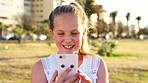 Child, laugh and scroll in park with phone, social media meme and notification for funny text message. Happy, girl and typing outdoor with tech, browsing website and mobile app for internet humor.