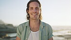 Adventure, face and man with smile at beach, relax or laughing on summer holiday in nature and break. Ocean, traveler and happy person on vacation, outdoor and humor on weekend in San Francisco