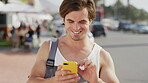 Scroll, laugh and man in town with phone, funny message or travel meme on social media. Happy, backpack and male person in city with technology, chat response and gif reaction on weekend break.