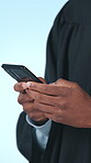 Graduate, texting and hands with smartphone in studio, online and communication with contact on web. Blue background, student and person with mobile for message, education or chatting on social media