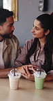 Couple, holding hands and milkshake on date at restaurant with connection, love and bonding. Man, woman and partner at cafe for drinks with relationship, smile or trust with loyalty at coffee shop