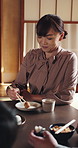 Eating, food and woman in dining room with family for feast, hunger or Japanese meal together. Bonding, chopsticks and Takoyaki with happy person in apartment for gourmet or traditional cuisine