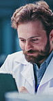 Man, scientist and typing with tablet in lab for research, test results and experiment report. Thinking, person and digital for medical trial, healthcare study and information for vaccine development