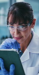 Thinking, woman and scientist with tablet in lab for research, test results and experiment. Mature person, reading and digital for medical trial, healthcare study and solution for vaccine development