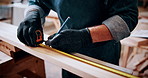 Person, hands and carpenter with measuring tape for lumber project, furniture or accuracy in workshop. Man, measurement or pencil marking on wood plank for timber fit, precision skill or dimension